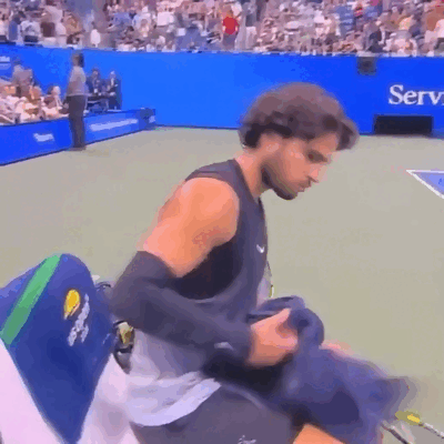 Alcaraz assis au bord du court de tennis exprime son refus.