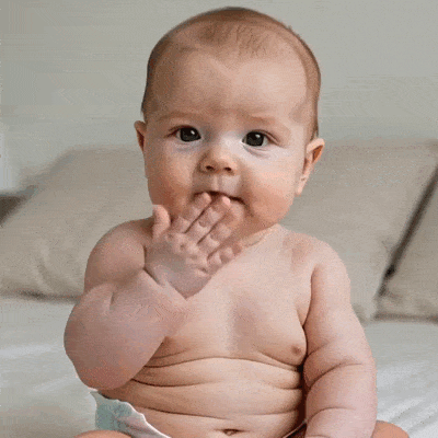 Un bébé envoie un bisou avec sa main.