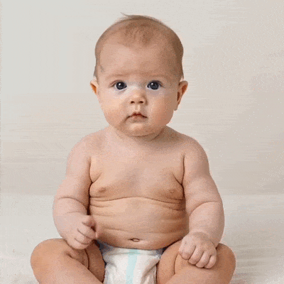 Un bébé fait non avec son doigt et tourne la tête.