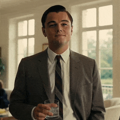 DiCaprio lève son verre en souriant pour porter un toast.