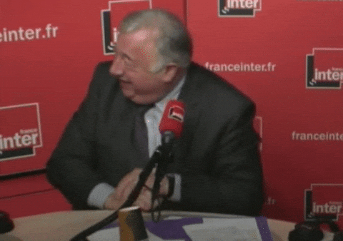 Gérard Larcher rit, assis devant un microphone dans un studio de France Inter.
