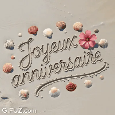 Feliz Cumpleaños está escrito en la arena entre conchas marinas y una flor rosa.