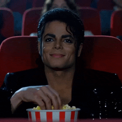 Michael Jackson mange du popcorn en regardant un film au cinéma.
