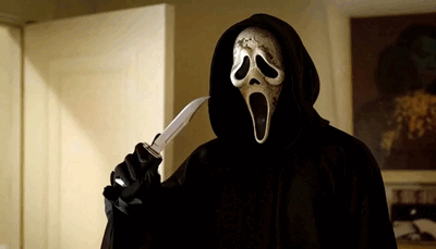 A figure dressed in black wears the Scream mask and holds a knife near their face.